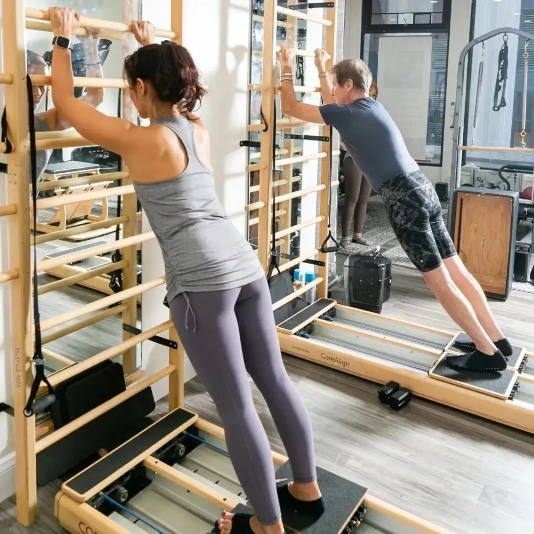 Two people exercising on fitness machines.
